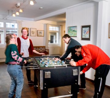 vier personen spielen an einem Kicker