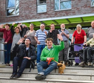 Gruppenfoto mit winkenden Menschen