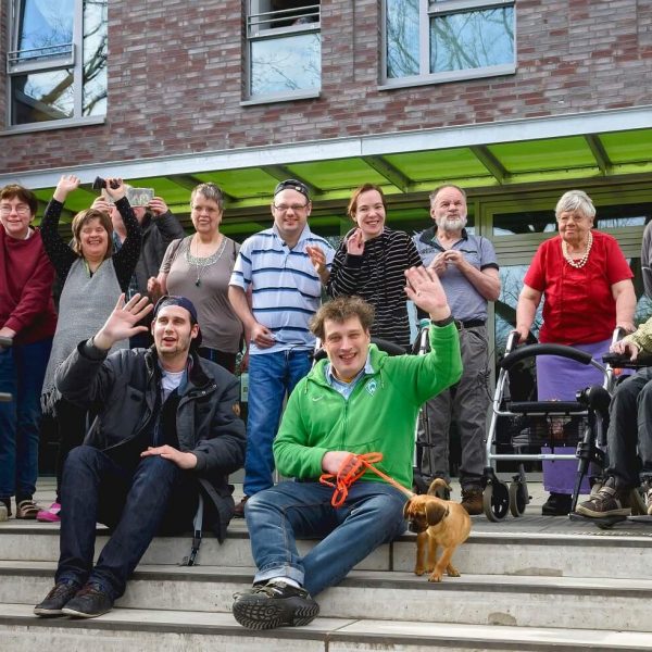Gruppenfoto mit winkenden Menschen