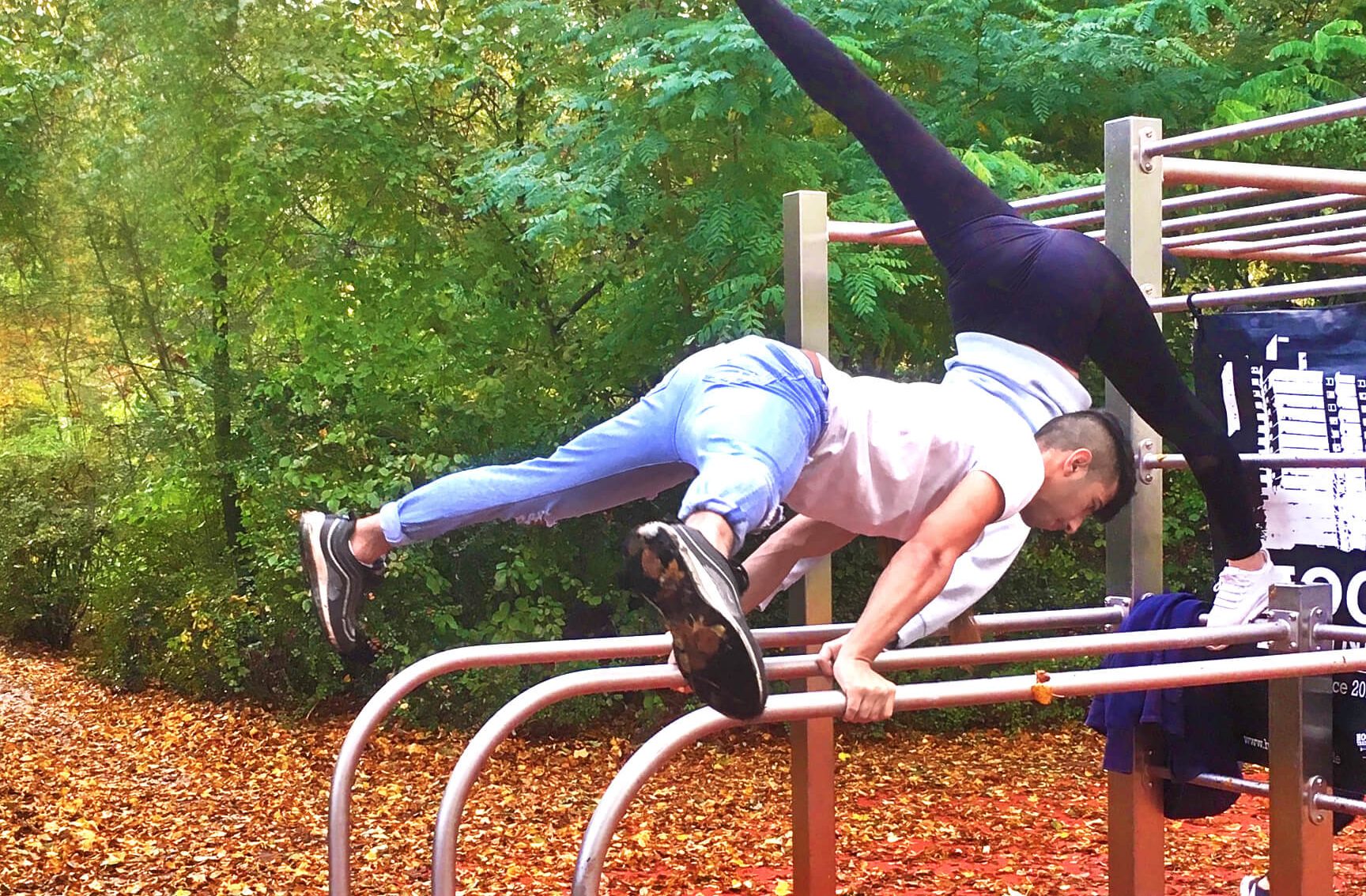 Junge Menschen trainieren am Barren draußen