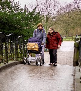 Paar geht mit Kinderwagen spazieren 