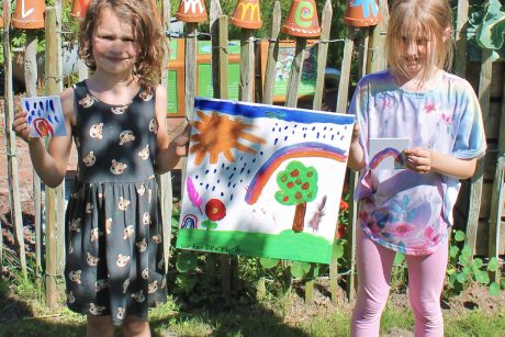 Kinder halten selbst gemaltes Bild in der Hand