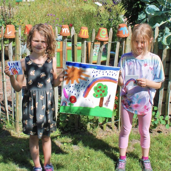 Kinder halten selbst gemaltes Bild in der Hand
