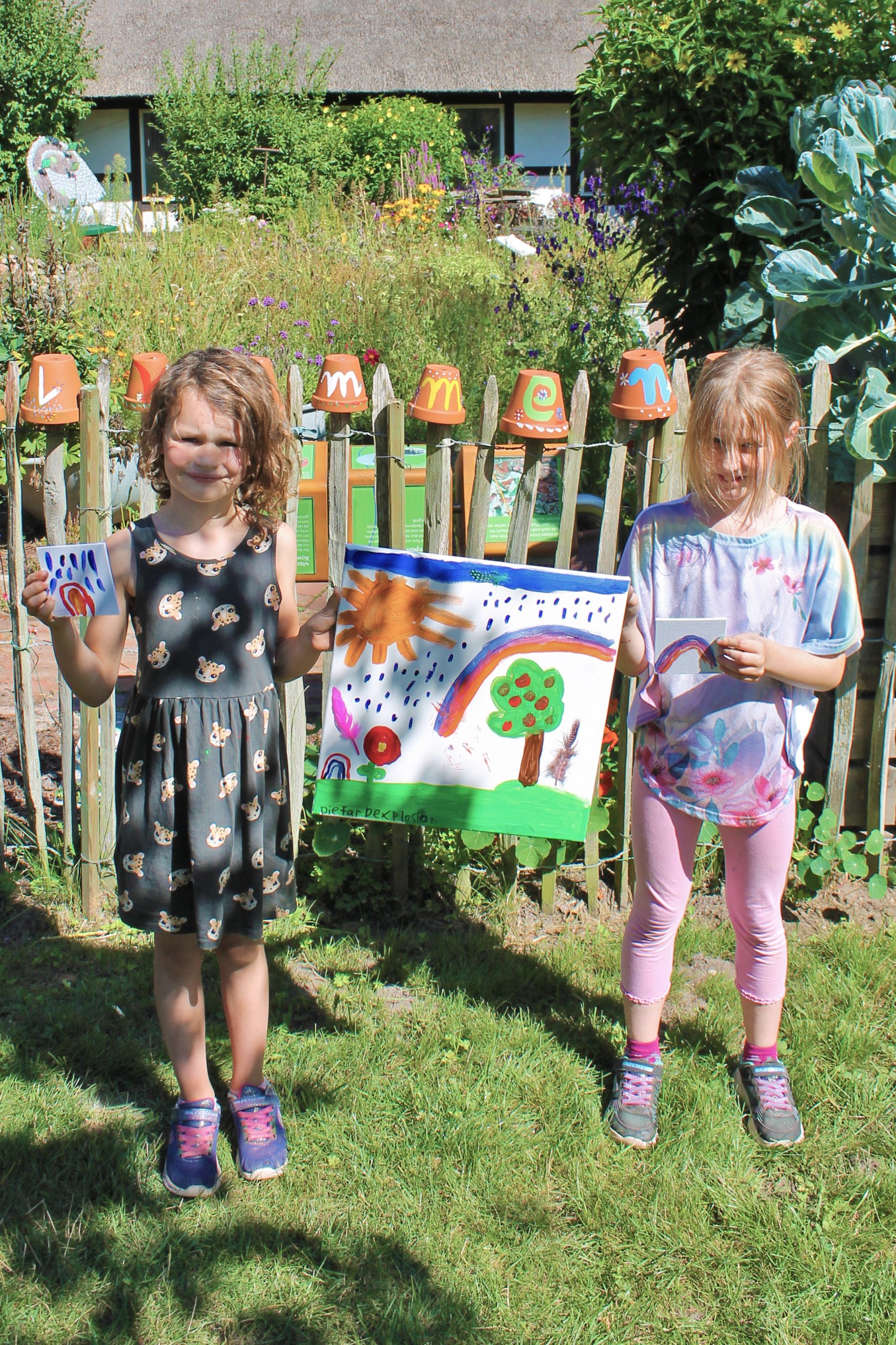 Kinder halten selbst gemaltes Bild in der Hand