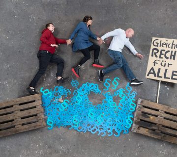 drei Menschen springen über ein Meer aus Paragraphen