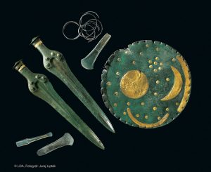 Die Himmlescheibe von Nebra mit ihren Beifunden: zwei Schwerter, zwei Beile, Armringe und Meißel aus Bronze