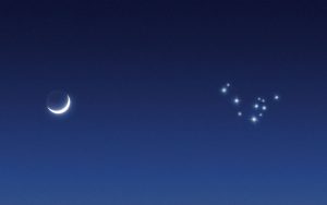 Ein Sichelmond und ein Sternenbild am Nachthimmel