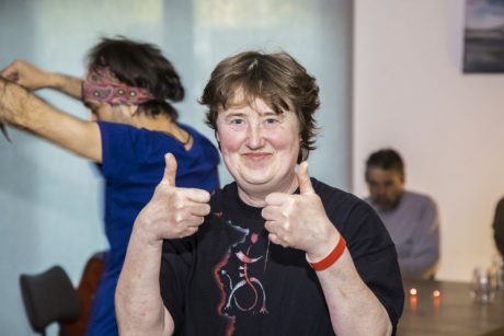 Frau guckt in die Kamera und zeigt zwei Daumen hoch