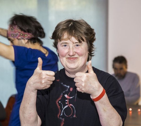 Frau guckt in die Kamera und zeigt zwei Daumen hoch