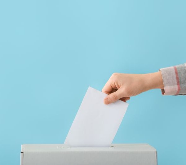 Jemand wirft einen Wählzettel ein.