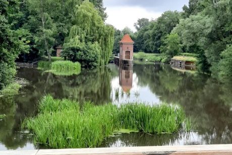 Ein See im Grünen mit kleinen Häuschen