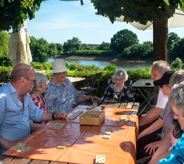 Ältere Menschen beim Schnack draußen an einem Tisch