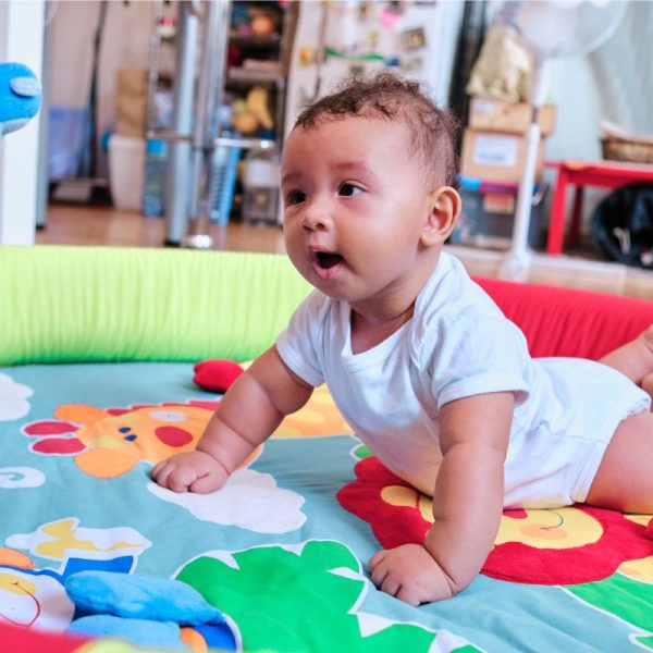 Ein Baby auf einem Spielteppich