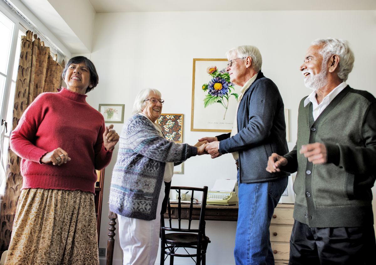 Senior friends dancing together at home